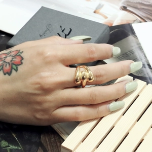 Detailed view of an 18K gold plated stainless steel knot ring on a model's finger