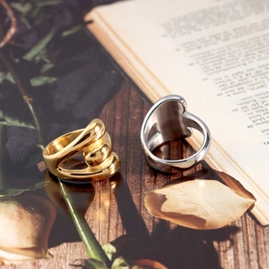 Detailed view of 18K gold plated twisted band and silver heart ring on vintage book
