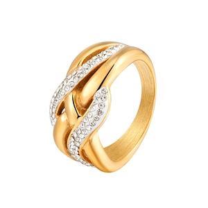 Macro shot of gold-plated intertwined ring with three rows of sparkling white crystals