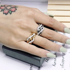 Close-up of twisted braided 18K gold and silver rings with cubic zirconia pavé setting