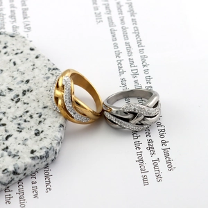 Macro shot of gold and silver interwoven rings with pavé set crystals on marble