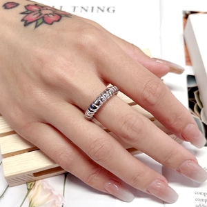 Detailed close-up of a silver croissant ring showing twisted texture on model's finger