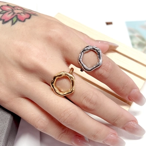 Close-up of irregular wave titanium steel rings in gold and silver on fingers