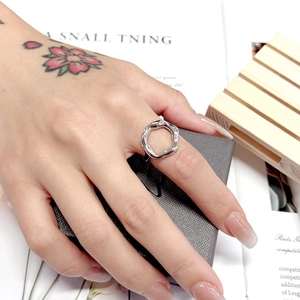 Close-up of a silver liquid metal ring worn on a hand over a leather jewelry box