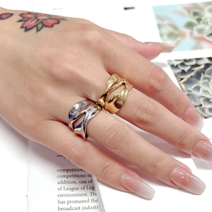 Close-up of irregular twisted hollow rings in gold and silver finish on hand