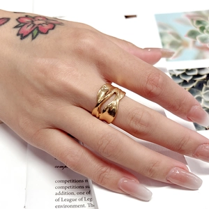 Detailed close-up of a wide irregular liquid metal ring in polished 18K gold finish