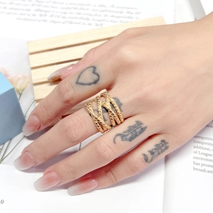 Detail of bohemian gold layered rope texture ring worn on hand with wide band design
