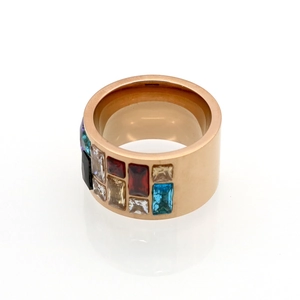 Macro view of rose gold wide band ring set with colorful rectangular gemstones