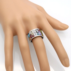 Detail of wide stainless steel ring featuring multi-colored rectangular zircon stones