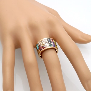Macro shot of gold wide band ring with multi-color rectangular zircon stones on hand