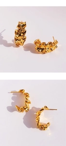 Detailed view of gold C-shaped earrings featuring a stylish wrinkled foil texture finish