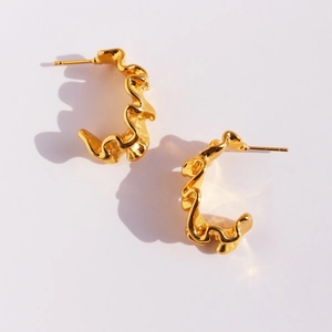 Polished gold wavy C-shape hoop earrings with artistic pleated texture on white background