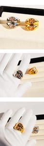 Detail of heavy double-layered wide metal ring with dual oval champagne gemstones