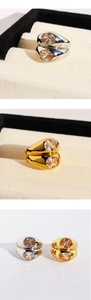Macro detail of double-layer wide rings with oval zircon stones in gold and silver finish