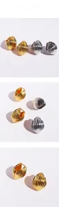 Détails de la texture nervurée en forme de coquillage des boucles d'oreilles or et argent