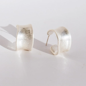 Zilveren brede C-vormige oorringen met vintage golfstructuur en matte metalen finish