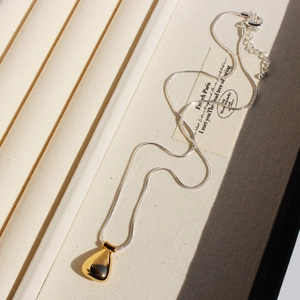 Retro two-tone water drop pendant with silver snake chain displayed in a jewelry box