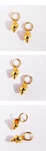 Detailed macro view of 3D gold conch shell earrings with polished metal texture
