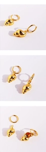 Detailed macro view of gold-plated conch shell earrings with polished metal texture