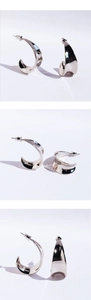 Vue macro des boucles d'oreilles créoles larges en argent poli effet miroir