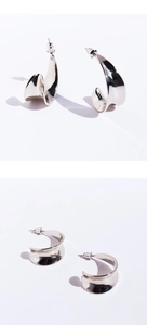 Gros plan de boucles d'oreilles incurvées en forme de C avec finition miroir polie