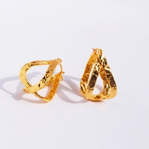 Boucles d'oreilles créoles dorées martelées à texture de lave sur fond blanc