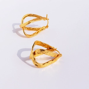 Boucles d'oreilles dorées avec texture de lave artisanale et design géométrique croisé
