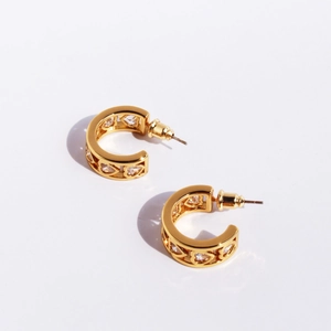 Elegant gold C-shaped hoop earrings featuring hollow heart patterns and zircon stones