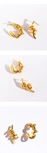 Detailed view of gold twist C-shape hoop earrings with a textured braided metal finish