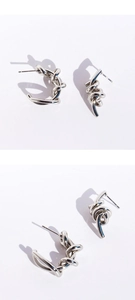 Macro view of silver twisted knot earrings with polished finish and irregular wire design