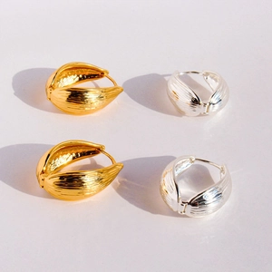 Détails des boucles d'oreilles feuille avec texture brossée en finition or et argent