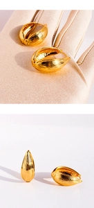 Détail des boucles d'oreilles dorées en forme de goutte avec texture brossée et martelée