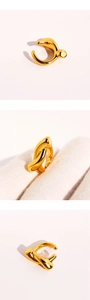 Macro detail of organic knot-shaped gold cuff earring with polished mirror surface