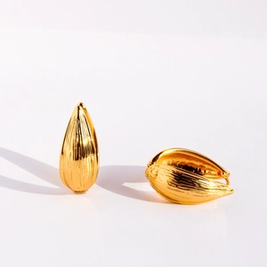 Boucles d'oreilles feuilles dorées texturées avec finition métal brossé sur fond blanc