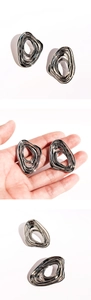 Close-up of silver irregular layered earrings showing polished metallic flowing curves