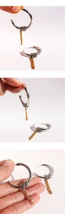 Detailed view of silver C-hoop earrings with gold chain wrap and metallic twist design