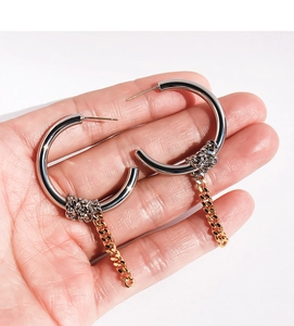 Close-up of gold and silver mixed metal hoop earrings with chunky hanging chain detail