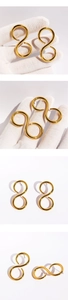 Detailed view of gold figure-eight earrings with polished metallic finish and smooth lines
