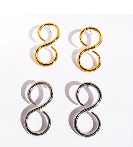 Macro shot of minimalist figure-eight stud earrings in polished gold and silver finishes