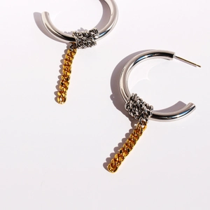 Two-tone silver C-hoop earrings with gold Cuban chain drop and woven knot details