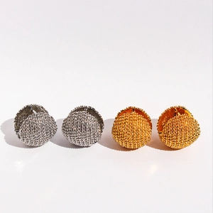 Détail des boucles d'oreilles sphères géométriques avec finitions texturées or et argent