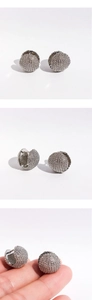 Vue détaillée des boucles d'oreilles boules argentées avec surface texturée brillante