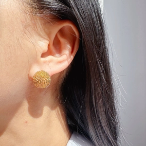 Boucles d'oreilles boules dorées élégantes avec fini scintillant sur le mannequin
