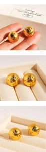 Detailed view of gold ball earrings with intricate woven texture and metallic luster