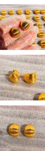Macro detail of golden curved stud earrings featuring refined vertical shell-like textures