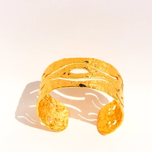 Wide vintage gold cuff bracelet with hammered texture and irregular hollow cut-outs