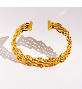 Detailed close-up of golden mesh woven wide open cuff bracelet with metallic textures