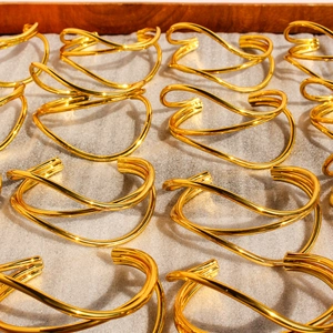 Polished gold multi-layer wave hollow open wide cuff bracelet in an array display
