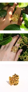Vista macro dell'anello floreale dorato che mostra la trama dei petali fini
