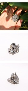 Dettaglio dell'anello floreale argento con petali traforati a strati e design regolabile